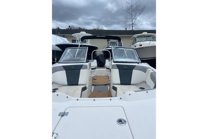 Slide: The Image of 2021 Chaparral 230 Suncoast boat with dual consoles and seating, under cloudy skies. - 20