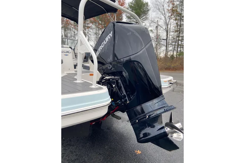 Slide: The Image of 2021 Chaparral 230 Suncoast boat with Mercury outboard motor, parked outdoors. - 5