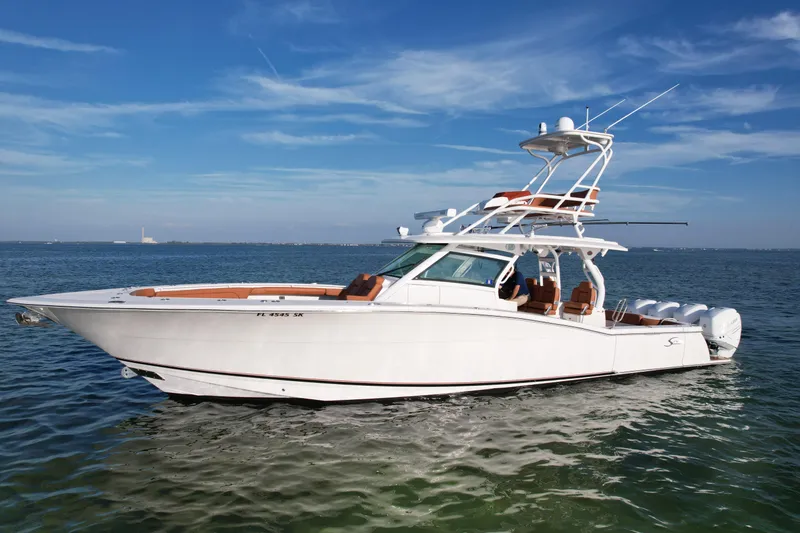The Image of 2019 Scout 420 LXF boat on calm water under clear blue sky. - 0