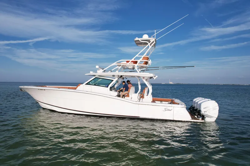 Slide: The Image of 2019 Scout 420 LXF boat cruising on open water under clear blue skies. - 1