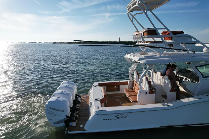 Slide: The Image of 2019 Scout 420 LXF boat on calm water, featuring dual Mercury engines. - 13
