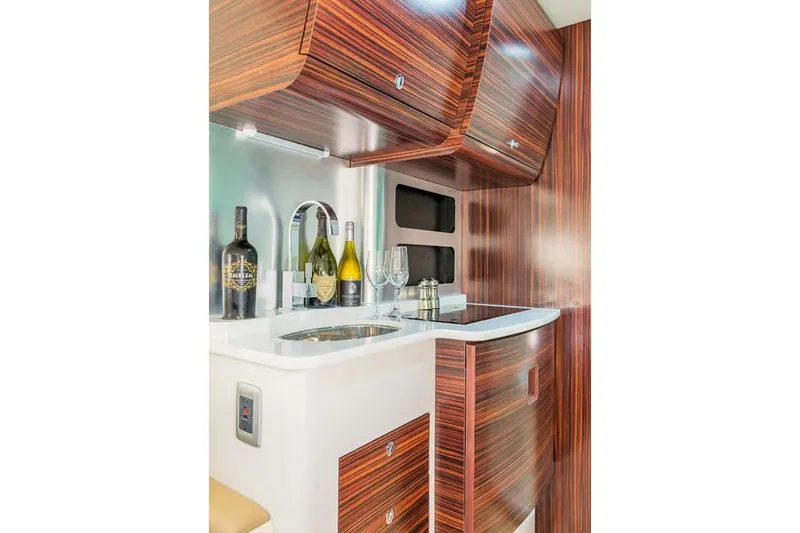 Slide: The Image of 2019 Scout 420 LXF boat in a marina lift under clear blue sky. - 35