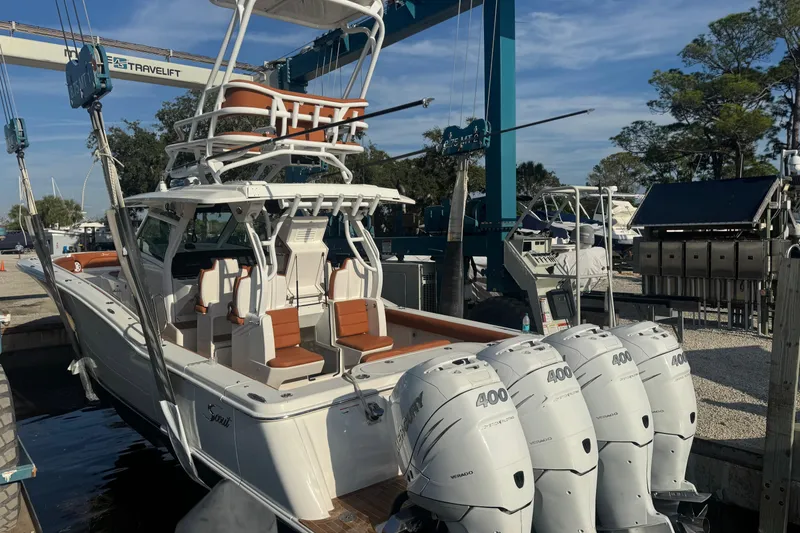Slide: The Image of 2019 Scout 420 LXF boat with quad 400 engines in a marina setting. - 37