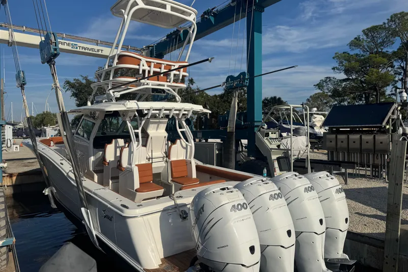 Slide: The Image of 2019 Scout 420 LXF boat with four powerful outboard engines at a marina. - 38