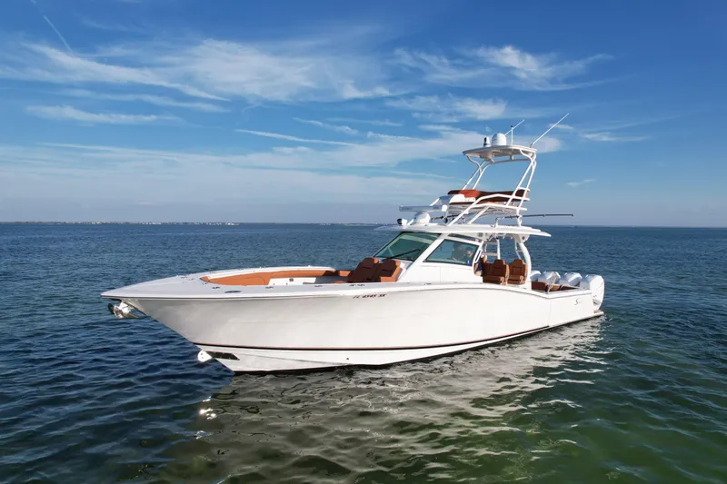 Slide: The Image of 2019 Scout 420 LXF luxury boat on calm ocean waters under clear blue sky. - 4