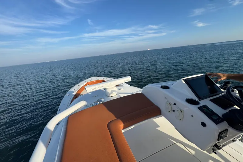 Slide: The Image of 2019 Scout 420 LXF boat on open water with clear blue sky. - 40