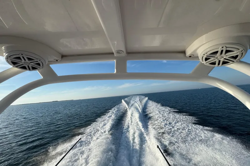 Slide: The Image of 2019 Scout 420 LXF boat cruising on open water, leaving a wake trail. - 42