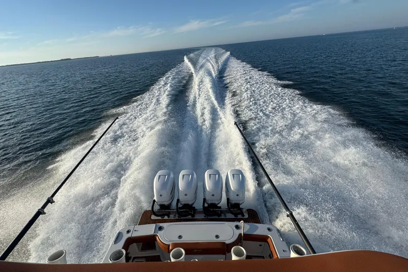 Slide: The Image of 2019 Scout 420 LXF boat cruising on open water, leaving a wake behind. - 43