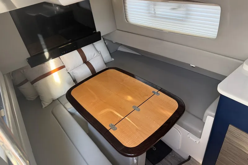 Slide: The Image of 2019 Scout 420 LXF interior with cozy seating, wooden table, and pillows. - 44