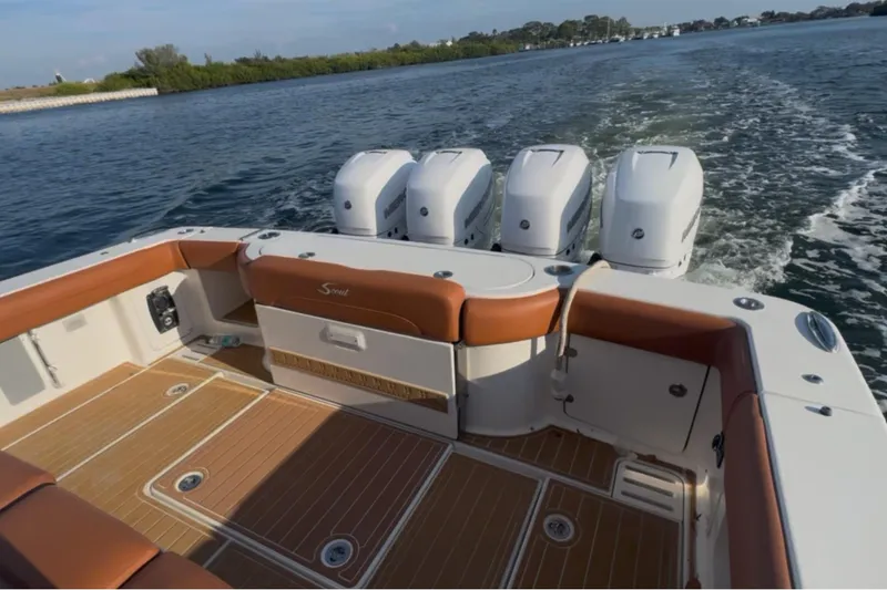 Slide: The Image of 2019 Scout 420 LXF boat with quad engines cruising on open water. - 48