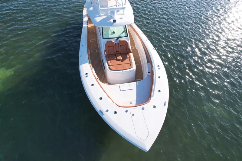 Slide: The Image of 2019 Scout 420 LXF boat on water, aerial view, sleek design, luxury seating. - 6