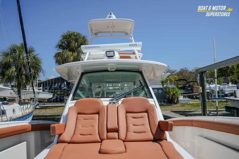 Slide: The Image of 2019 Scout 420 LXF boat with luxurious seating and Garmin equipment at a marina. - 65