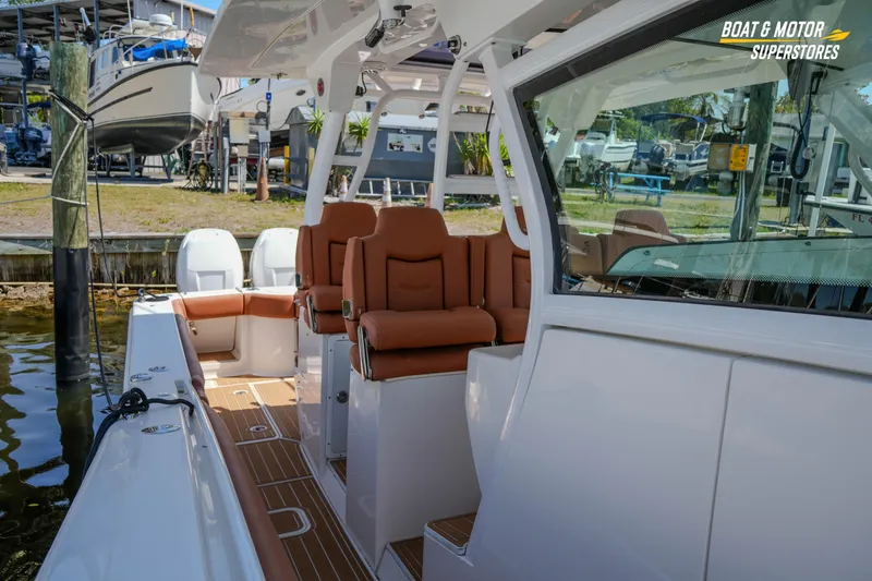 Slide: The Image of 2019 Scout 420 LXF boat interior with brown seating at a marina. - 68