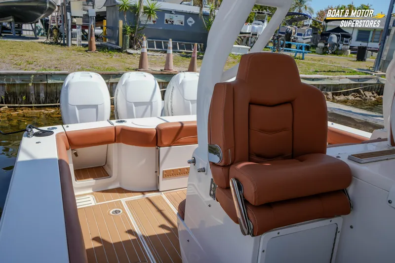 Slide: The Image of 2019 Scout 420 LXF boat interior with brown seating and triple outboard engines. - 70