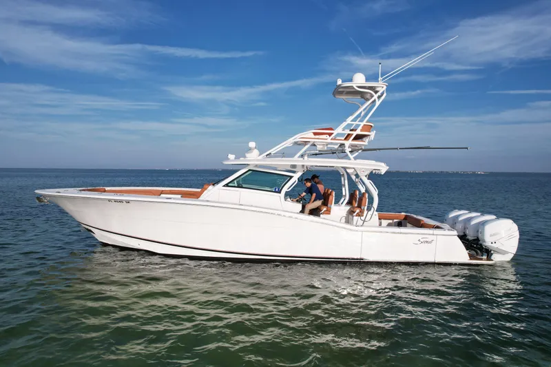 Slide: The Image of 2019 Scout 420 LXF boat cruising on calm ocean waters under a clear blue sky. - 8