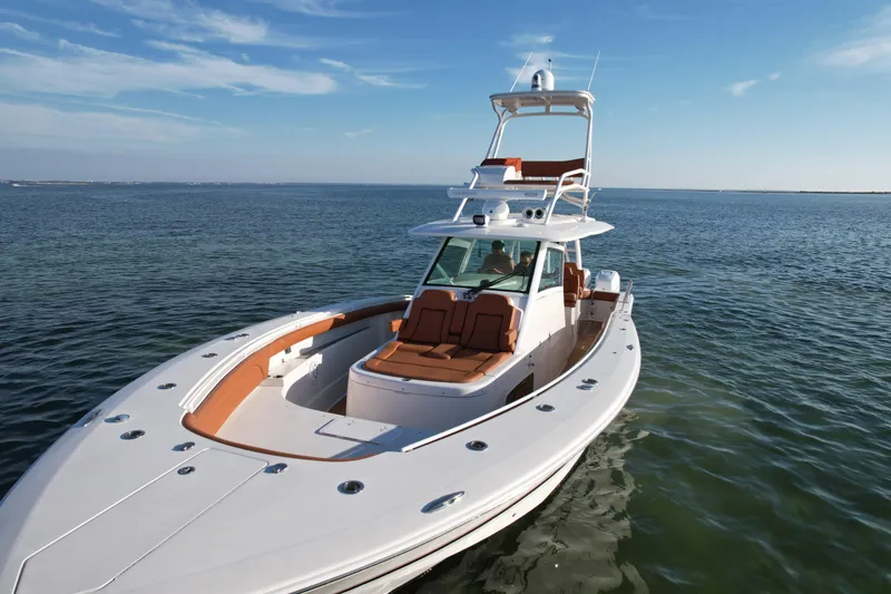 Slide: The Image of 2019 Scout 420 LXF boat on calm ocean waters under clear blue sky. - 9