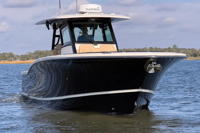 Slide: The Image of 2022 Scout 330 LXF boat cruising on calm water with Garmin equipment. - 11