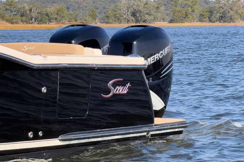 Slide: The Image of 2022 Scout 330 LXF boat with dual Mercury engines on a serene lake. - 16
