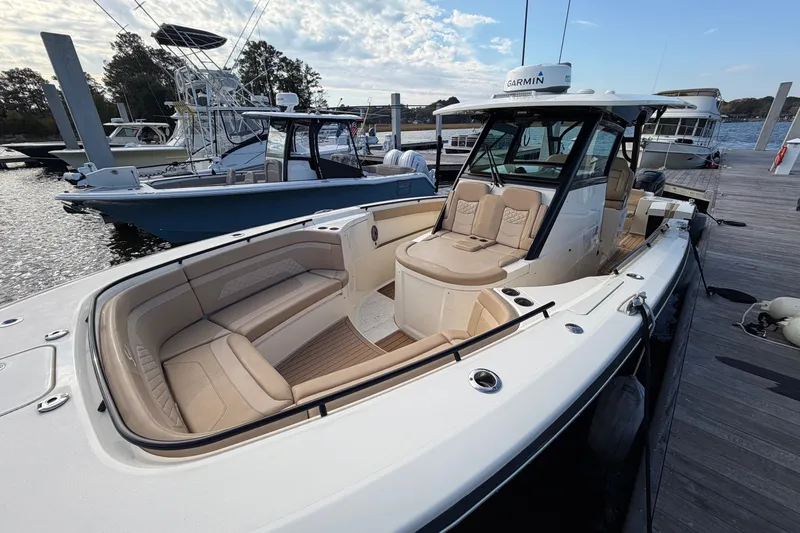 Slide: The Image of 2022 Scout 330 LXF boat docked, featuring luxurious seating and modern design. - 17