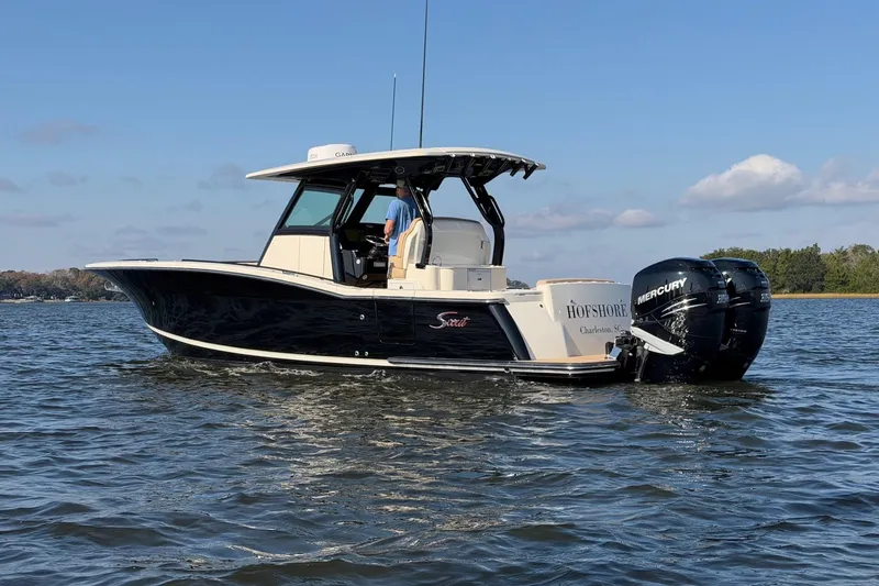Slide: The Image of 2022 Scout 330 LXF boat on water with dual Mercury engines. - 3