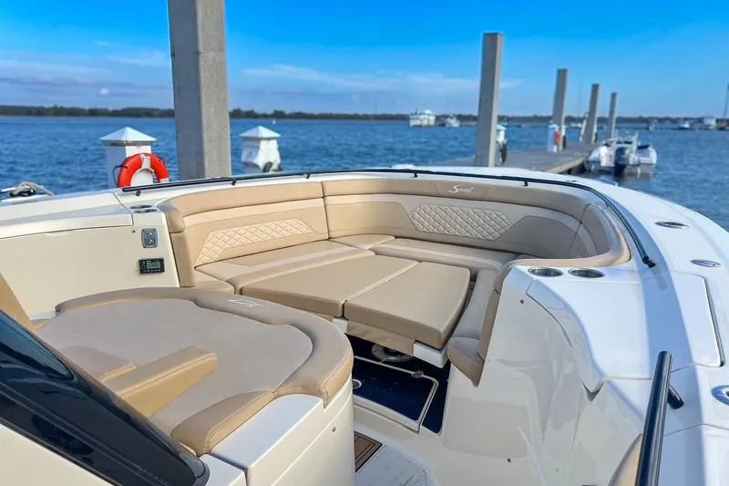 Slide: The Image of Luxurious seating on 2022 Scout 330 LXF boat docked by the water. - 34