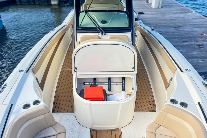 Slide: The Image of 2022 Scout 330 LXF boat interior with open storage compartment on a dock. - 37
