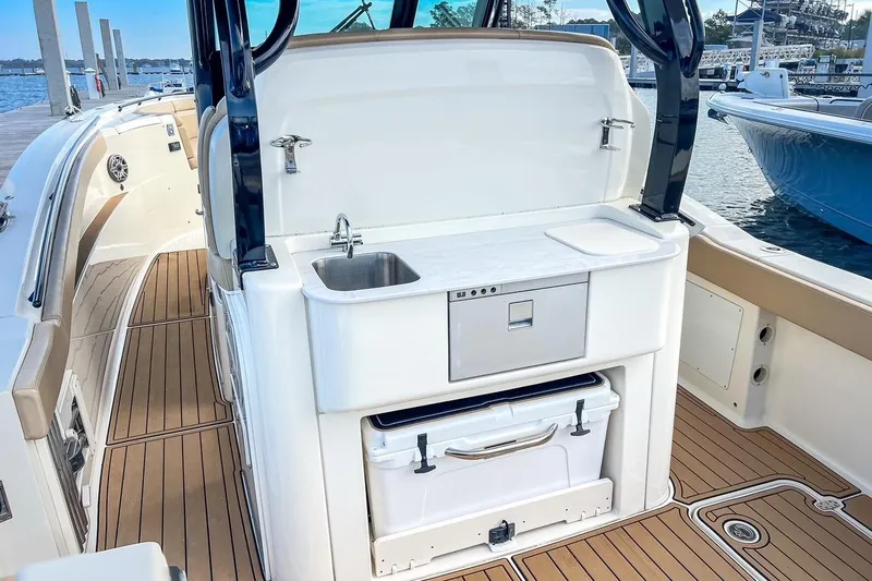 Slide: The Image of 2022 Scout 330 LXF boat interior with sink and storage on deck. - 44