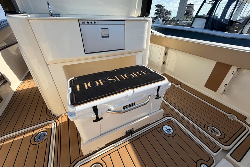 Slide: The Image of 2022 Scout 330 LXF boat interior with YETI cooler and teak flooring. - 46