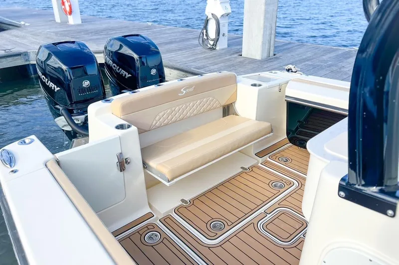 Slide: The Image of 2022 Scout 330 LXF boat interior with twin Mercury engines at dock. - 47