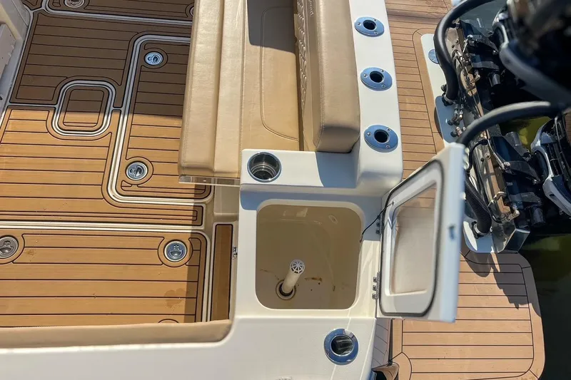 Slide: The Image of 2022 Scout 330 LXF boat deck with seating, rod holders, and open storage compartment. - 49