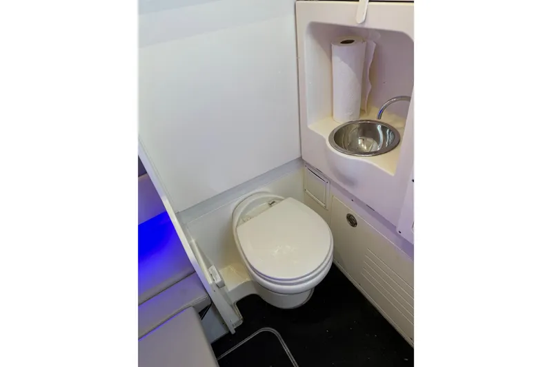 Slide: The Image of 2022 Scout 330 LXF boat bathroom with toilet, sink, and paper towel holder. - 58
