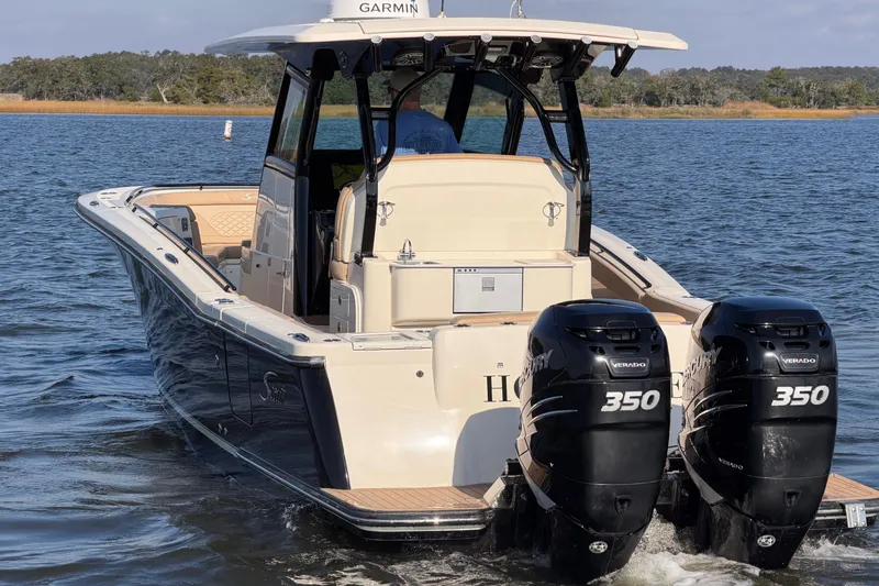 Slide: The Image of 2022 Scout 330 LXF boat with twin Mercury 350 engines on the water. - 6
