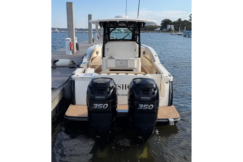 Slide: The Image of 2022 Scout 330 LXF boat with twin 350 Verado engines docked at marina. - 76