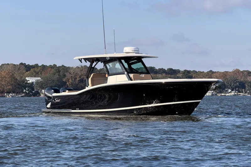 Slide: The Image of 2022 Scout 330 LXF boat cruising on a calm lake with scenic background. - 9