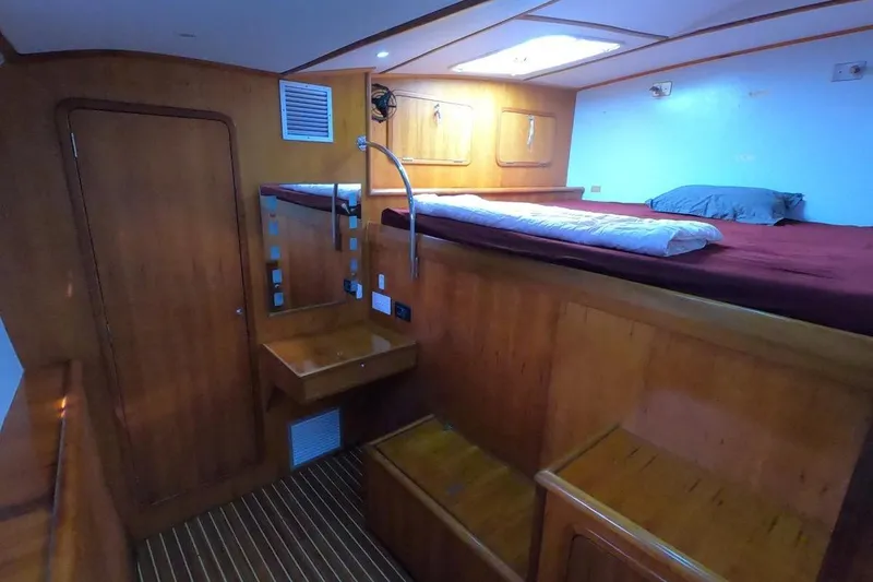 Slide: The Image of Luxurious 2006 Maxim Yachts 57 interior cabin with wooden finish and cozy bedding. - 27