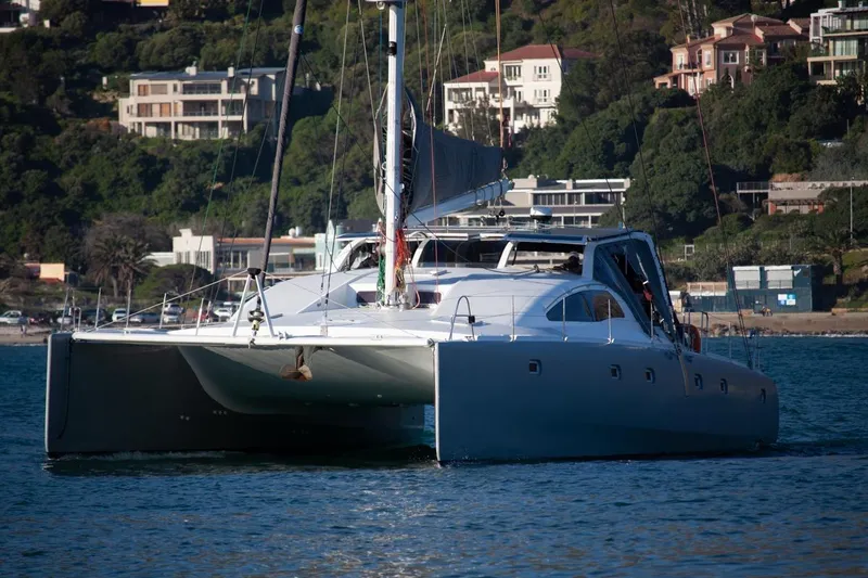 Slide: The Image of 2006 Maxim Yachts 57 catamaran sailing near a coastal residential area. - 37