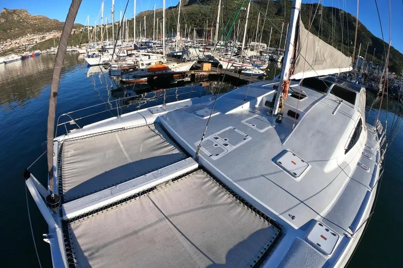 Slide: The Image of 2006 Maxim Yachts 57 sailboat docked in a scenic marina with surrounding hills. - 5