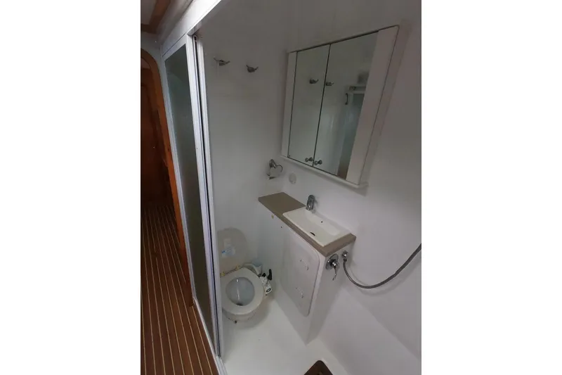 Slide: The Image of Bathroom interior of 2006 Maxim Yachts 57, featuring sink, toilet, and mirror cabinet. - 28