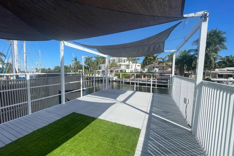 Slide: The Image of Modern Struktures MS400 deck with shade sails, overlooking a serene waterfront, 2023 model. - 11