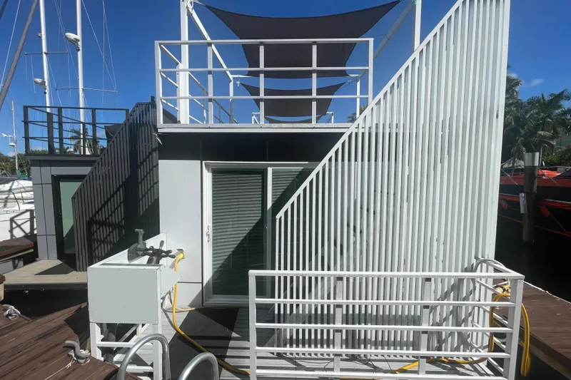 Slide: The Image of Modern Struktures MS400 houseboat, 2023 model, docked with sleek design and rooftop deck. - 2