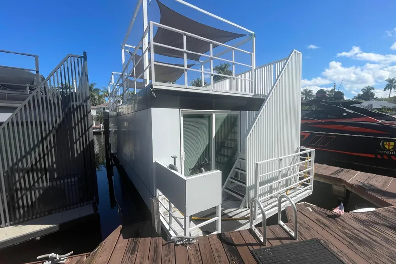 Slide: The Image of Modern Struktures MS400 houseboat, 2023 model, docked under clear blue sky. - 3