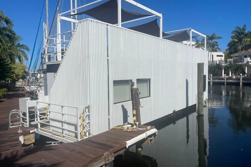 Slide: The Image of Modern Struktures MS400 houseboat docked, featuring sleek design and waterfront setting, 2023 model. - 5