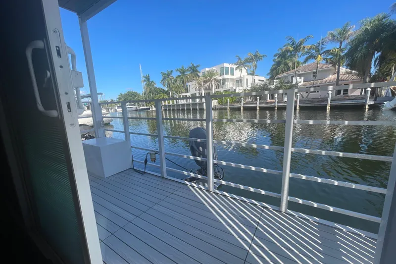 Slide: The Image of Modern Struktures MS400 houseboat deck overlooking serene waterfront with palm trees, 2023. - 6