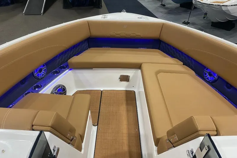 Slide: The Image of Luxurious seating area on 2026 Four Winns H33 boat with tan upholstery and blue LED lighting. - 13