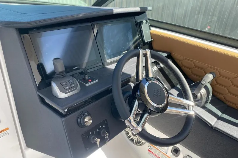 Slide: The Image of 2026 Four Winns H33 helm with modern controls and dual display screens. - 15