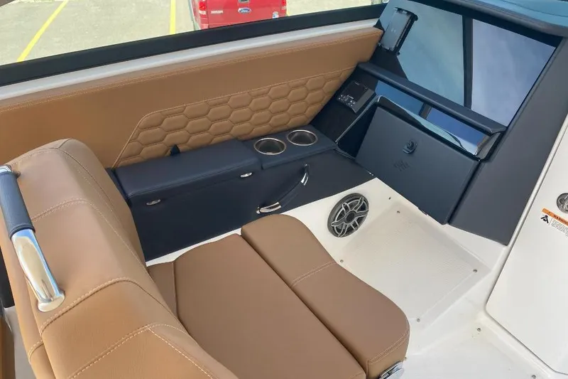 Slide: The Image of 2026 Four Winns H33 boat interior with brown seating and modern dashboard design. - 16