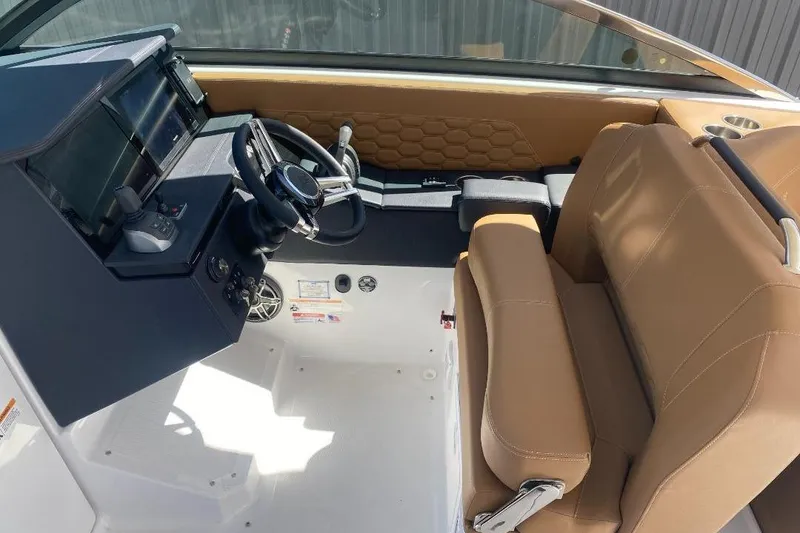 Slide: The Image of Interior of 2026 Four Winns H33 boat with tan seating and modern dashboard. - 17