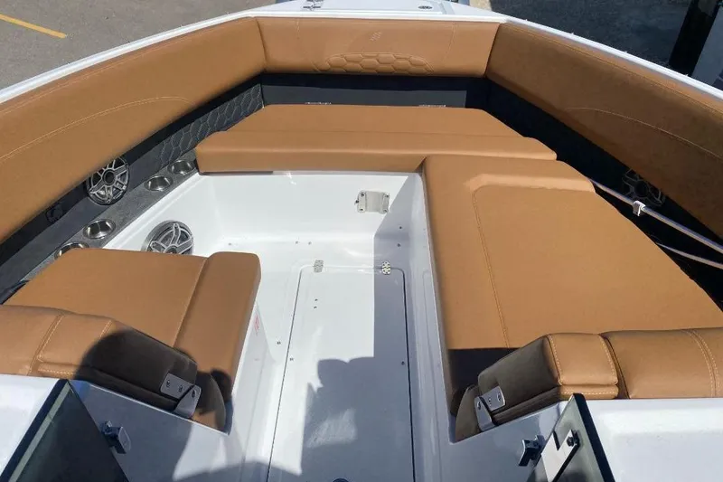 Slide: The Image of 2026 Four Winns H33 boat interior with tan seating and built-in speakers. - 20