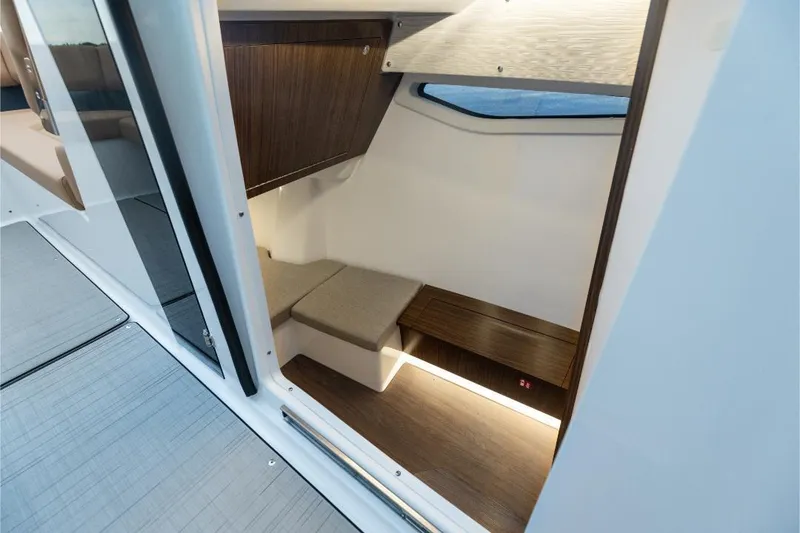 Slide: The Image of Luxurious interior of 2026 Four Winns H33 boat with tan seating and blue LED lighting. - 5