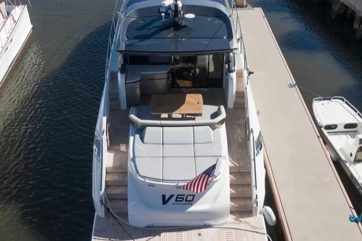 Slide: The Image of 2019 Princess V60 yacht docked, rear view with American flag and spacious deck. - 3